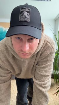 Μπεζ φούτερ με μαλακή υφή, μαύρο καπέλο με λογότυπο βουνού, σκούρα τζιν και ουδέτερο φόντο με ένα φυτό.