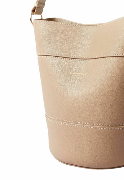 Borsa a secchiello in pelle beige con finitura testurizzata, con doppia cucitura e dettaglio logo dorato. Tracolla regolabile per praticità nel trasporto.