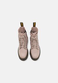 Botas de cuero rosas con cordones, punta redonda, cremalleras laterales, tiradores negros y amarillos, y una suela negra gruesa con costuras amarillas.