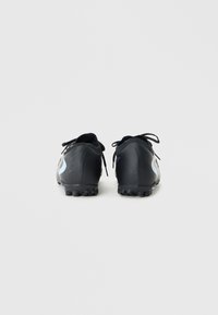 Botas de fútbol negras con material sintético suave, con un acento azul claro en los costados, punta redondeada y tacos de goma en la suela.