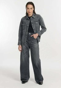 Grijze denimjas met bijpassende hoge wijdvallende jeans. Klassiek ontwerp met voorzakken en drukknoopsluiting op de jas.