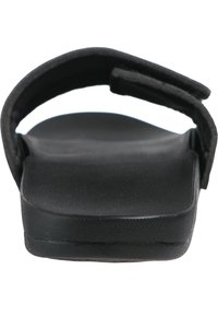 Svart slidsandal med en texturerad övre rem, platt sula och en dämpad fotbädd, designad för komfort och enkel användning.