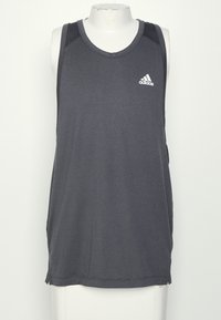 Tmavě šedý bezrukávový sportovní top Adidas na bílém manekýnu na čistě bílém pozadí.