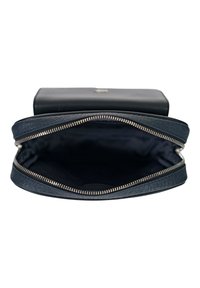 Portafoglio in pelle nera aperto completamente con cerniera metallica visibile e interno vuoto su sfondo bianco.