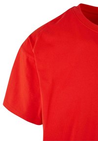 Rød bomulds T-shirt med klassisk rund hals og korte ærmer, med en glat overflade og ensartet farve hele vejen igennem.