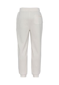 Kremowe dresy z miękkiego materiału, z tapered leg design, elastycznym paskiem w talii i jedną tylną kieszenią.