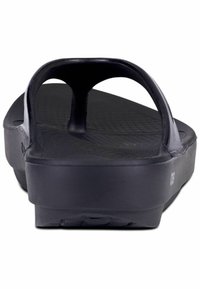 Mustat flip-flop sandaalit ovat muotoiltuja ja sileitä, leveällä varvastuella ja tekstuurilla varustetulla pohjalla pidon parantamiseksi sekä mukavuutta lisäävä kohotettu kanta.