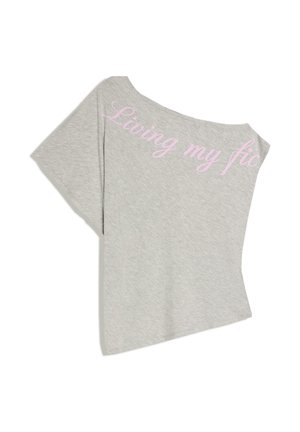 Világosszürke rövidített póló egy rövid ujjal és rózsaszín írott szöveggel, amely részben az "Élem a fikciómat" szavakat olvashatóvá teszi a nyakkivágás mentén.