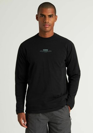 Zwarte langemouwen shirt met een ronde hals, voorzien van een klein blauw tekstlogo op de borst. De stof lijkt zacht en lichtgewicht te zijn.