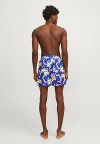 Blauwe zwembroek met een bloemenpatroon met roze bloemen en toekans. Gemaakt van lichtgewicht stof, met een elastische tailleband en een relaxte pasvorm.