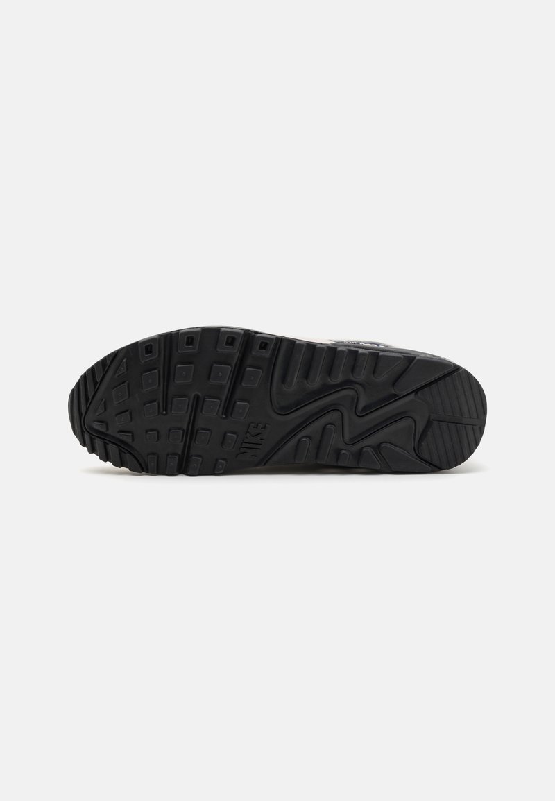 Schwarze Gummisohle mit strukturierten Griffmustern und prominentem Nike-Logo. Verfügt über eine genoppte Lauffläche für Haltbarkeit und Grip.