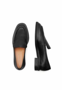 Czarne skórzane mokasyny o gładkiej teksturze, z okrągłym noskiem, minimalnym przeszyciem i niskim obcasem słupkowym. Widoczne beżowe wkładki.