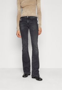 Ciemnoszare dżinsy w fasonie dzwonów, wykonane z denimu, z klasycznym pięciopunktowym wzornictwem i metalowym zapięciem. Gładka faktura i minimalne detale.