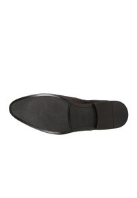 Zwarte leren schoen met een glad bovenwerk, ronde neus en een gestructureerde rubberen zool. Heeft minimale stiksels en geen zichtbare hardware.