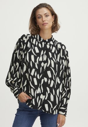 Black and white patterned blouse with a collared neckline, featuring long sleeves and a loose fit, made from a smooth, lightweight material.