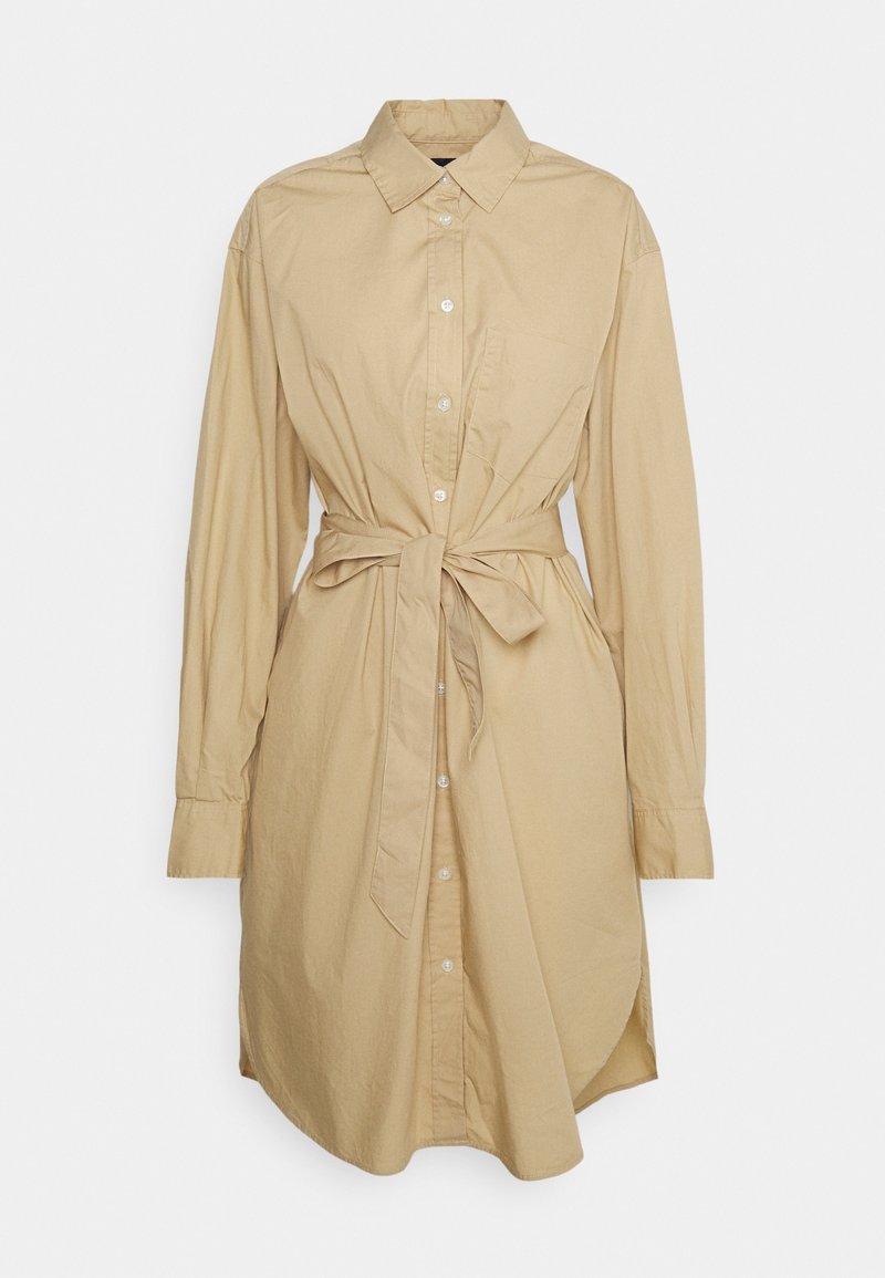 Robe chemise beige à boutons en coton, avec un col, des manches longues, une poche poitrine et une ceinture nouée à la taille.