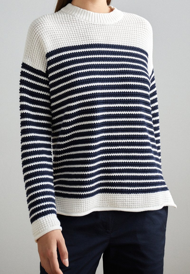 Maglione a righe navy e bianco in tessuto a maglia con scollatura a girocollo a coste e tessuto testurizzato. Presenta maniche lunghe e una vestibilità rilassata.