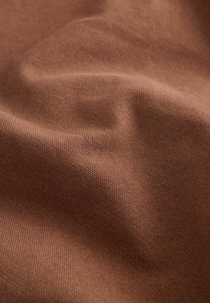 Tessuto marrone strutturato con una superficie liscia, caratterizzato da trame sottili e leggere ondulazioni, che indicano flessibilità e morbidezza.
