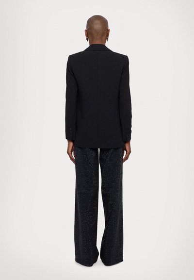 Black blazer with a tailored fit, paired with loose, sparkling black pants. The outfit features smooth textures and clean lines.