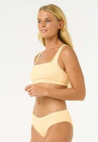 Gelbes Texturbikini-Set mit einem Oberteil mit eckigem Ausschnitt und breiten Trägern sowie passendem, tief sitzendem Höschen, das ein nahtloses Design zeigt.