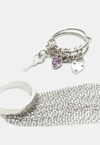 Sølv metal nøglering prydet med nøgler, hjerte og tåre charms, med et tekstureret kæde design.