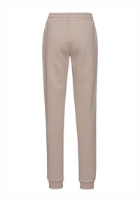 Beige Sweatpants aus weichem Baumwollmaterial, mit einem elastischen Bund, schmal geschnittenen Beinen und gerippten Bündchen an den Knöcheln.