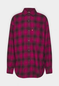 Chemise à manches longues avec motif à carreaux noir et rose foncé et poche poitrine du côté droit devant.