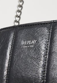 Zwarte gestructureerde synthetische leren handtas met een zilveren "REPLAY SINCE 1981" logo en een metalen kettingriem. Beschikt over gestikte panelen.