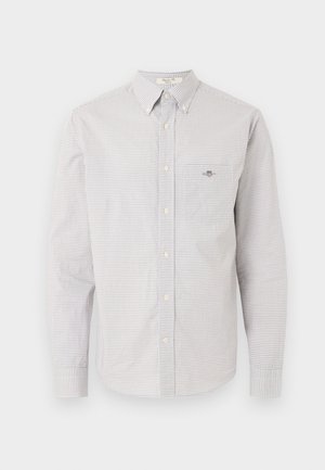 Πουκάμισο με μακριά μανίκια και κουμπιά, με μικρό καρό χρώμα σε λευκό και ανοιχτό καφέ, με μπροστινή τσέπη στο στήθος και γιακά με κουμπιά.