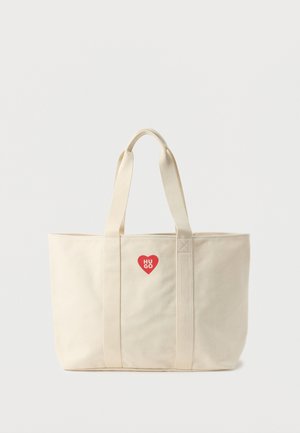 Sac fourre-tout en toile crème avec des bretelles doubles pour l'épaule et un petit logo cœur rouge avec le texte « HUGO » au centre avant.