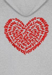 Felpa grigia con un grande cuore ricamato rosso, che presenta elementi testuali intrecciati e texture all'interno della forma del cuore.