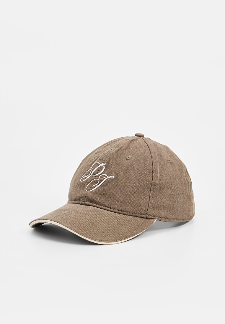 Gorra de béisbol de algodón marrón con logotipo bordado en blanco, visera curva y seis ojales para ventilación. Presenta un acento beige debajo de la visera.