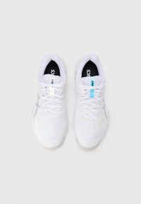 Ζευγάρι λευκά αθλητικά παπούτσια Asics με κορδόνια, μπλε και λευκές ετικέτες μάρκας στη γλώσσα, ορατά από πάνω σε απλό ανοιχτόχρωμο φόντο.