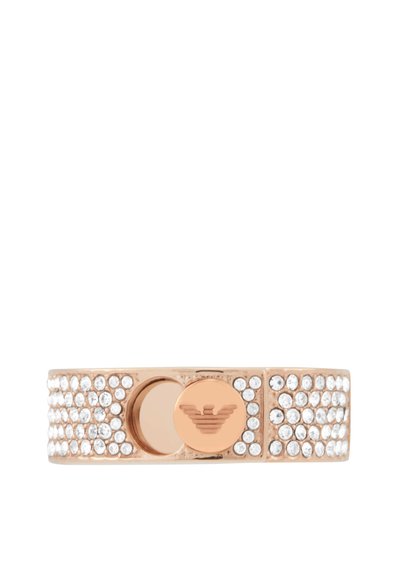 Armband i roséguld prydd med klara stenar, med ett centralt glänsande cirkulärt emblem med en örnlogotyp. Slät yta, modern design.