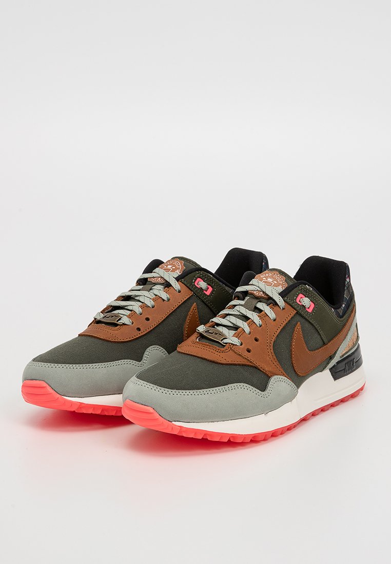 Sneakers Nike z zielono-brązową cholewą, szarymi zamszowymi akcentami i różową gumową podeszwą. Zawierają wzorzysty język i sznurówki w kolorze szarym.