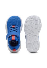 Blue athletic shoes with mesh upper, rubber sole, and adjustable strap. Features red accents on the tongue and heel. Textured white outsole.