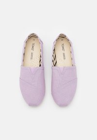 Ballerine in tela lilla con una trama a rete incrociata. V-elastico per una facile indossatura. L'interno presenta una fantasia a zigzag bianca e nera. Design leggero.