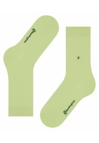 Chaussettes vert citron avec une texture lisse, comportant un logo vert foncé et un accent décoratif argenté sur une chaussette.