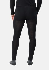 Schwarze Leggings aus einem weichen, elastischen Stoff, mit einem glatten Bund und enganliegendem Design, von hinten betrachtet.