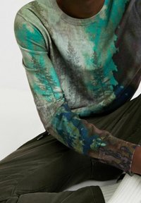 Trui van zacht materiaal met een meerkleurig bospatroon in groentinten en bruin. Geribbelde manchetten, ronde hals en een relaxte pasvorm.