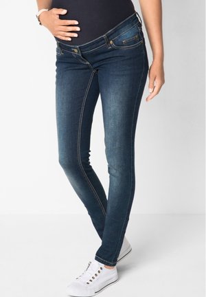 Jean skinny de maternité en denim bleu foncé avec des coutures claires. Doté d'un design classique à cinq poches et d'une taille confortable.