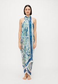 Bufanda fluida con un patrón floral en tonos de azul y verde, con un borde blanco. Hecha de un tejido ligero y transparente.