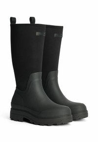 Mustat vedenpitävät saappaat, joissa on korkea muotoilu, valmistettu kumista ja tekstiilistä. Varusteena teksturoitu pohja ja vetotapit helppoa pukemista varten.