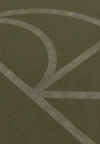 Tkanina oliwkowozielona o miękkiej fakturze z dużym, jasnoszarym, zakrzywionym wzorem graficznym. Widok z bliska podkreśla szczegóły wzoru.