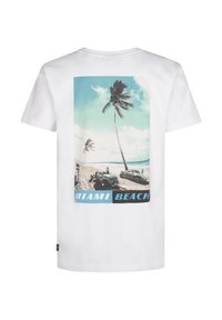 Witte T-shirt met een kleurrijke grafische print van Miami Beach met palmbomen, auto's, een blauwe lucht en water. De tekst luidt "MIAMI BEACH."