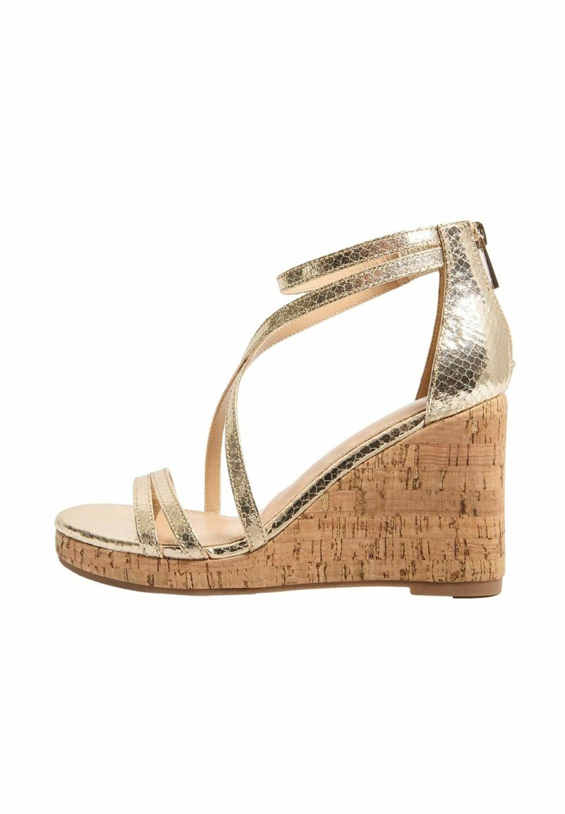 Goldene metallische Keilsandalette mit Korkplattform; verfügt über überkreuzte Riemen und einen Reißverschluss auf der Rückseite zum Verschließen. Glatte Textur, modernes Design.