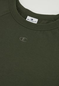 Camiseta de algodón color verde oscuro de cuello redondo con un escote acanalado y un pequeño logo bordado en el mismo color en el pecho.
