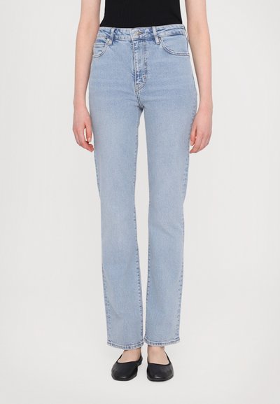 Jean en denim bleu clair avec une taille haute, coupe droite et un léger délavage. Présente un design classique à cinq poches et des éléments en métal.
