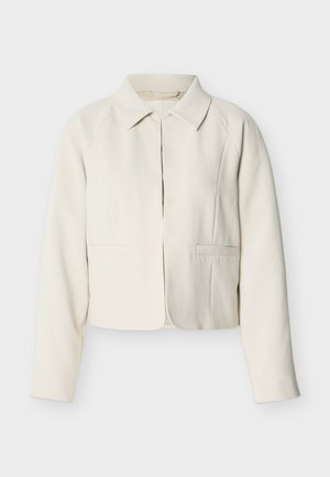 Blazer corto color avorio con maniche lunghe, colletto classico e due tasche a filetto frontali, esposto su uno sfondo chiaro e semplice.