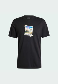 T-shirt en coton noir avec un graphique central représentant un paysage dans un design de cadre photo, avec des accents de bande adhésive pâle. Col ras du cou, manches courtes.